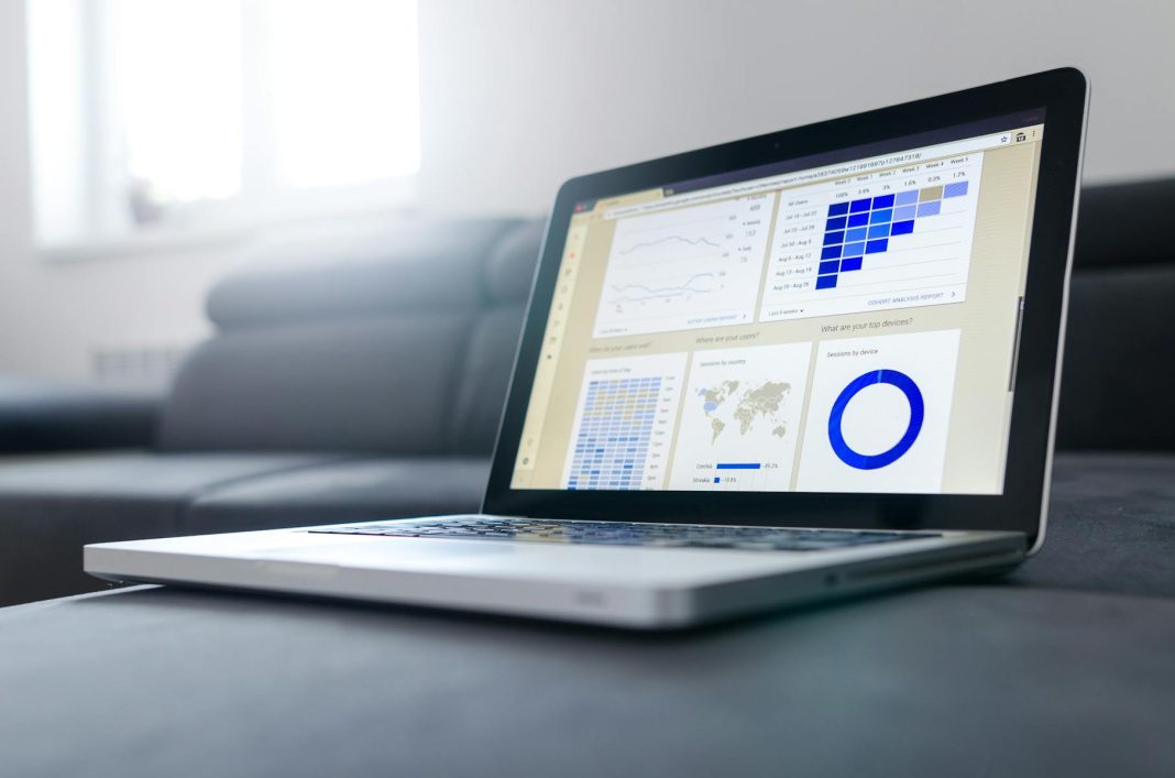 Photo by Lukas Sleek laptop showcasing data analytics and graphs on the screen in a bright room.