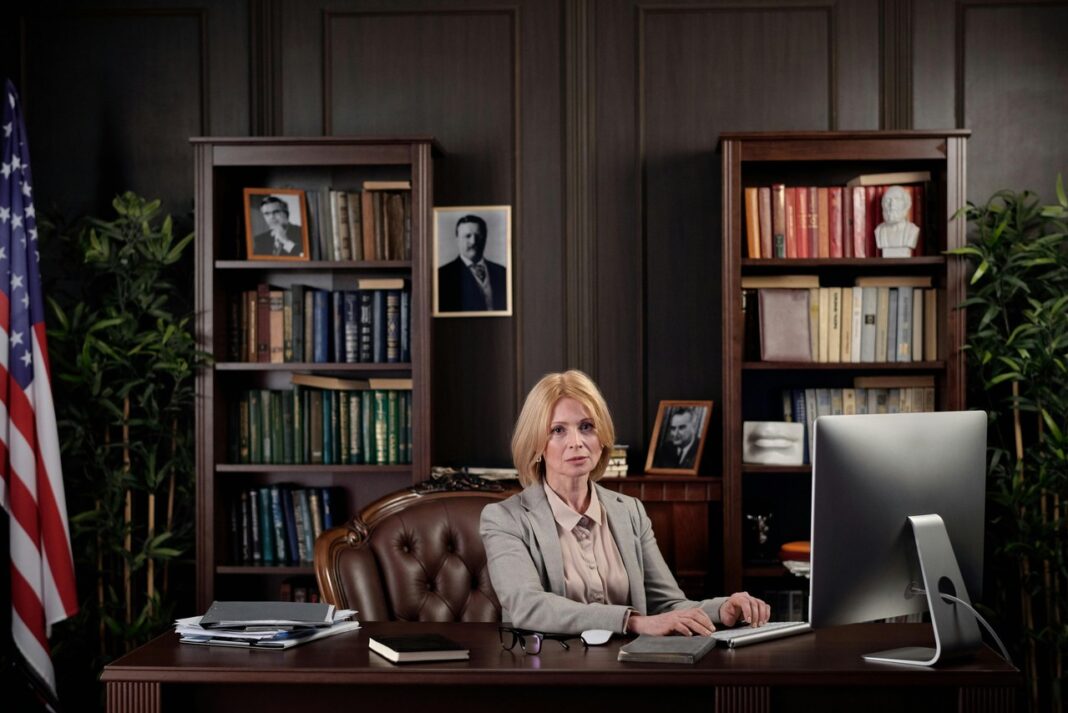 Executive office environment representing professional credibility for California law firm directory listing Professional woman working at an executive desk in a traditional wood-paneled office, illustrating the credible professional environment featured in California law firm directories.