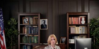 Professional woman working at an executive desk in a traditional wood-paneled office, illustrating the credible professional environment featured in California law firm directories.
