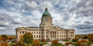 Neoclassical state capitol building with green copper dome surrounded by autumn trees, representing governmental authority for law firm directory inclusion.